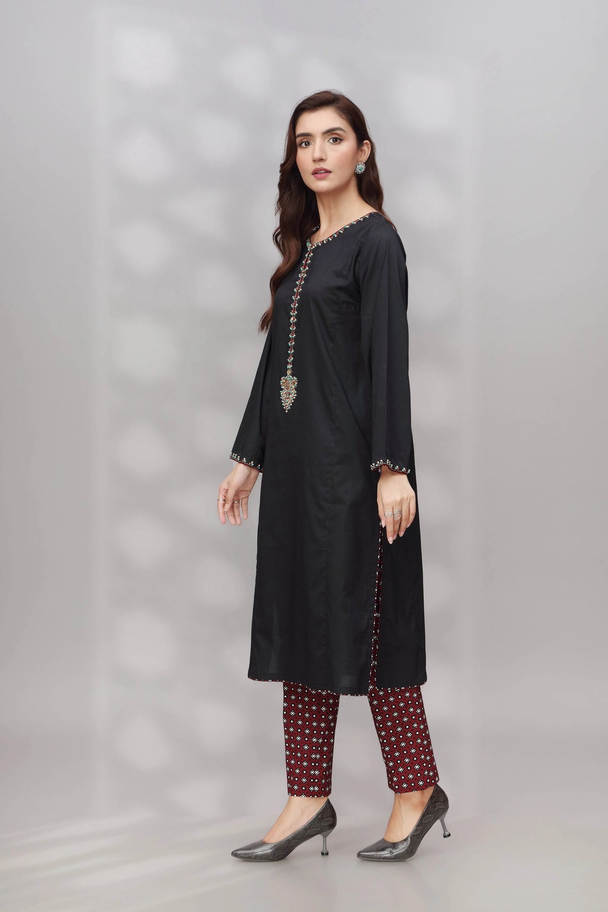 Side profile of Chinyere’s black dobbi suit, showcasing its fine tailoring – a must-have for Punjabi suits in Canada.