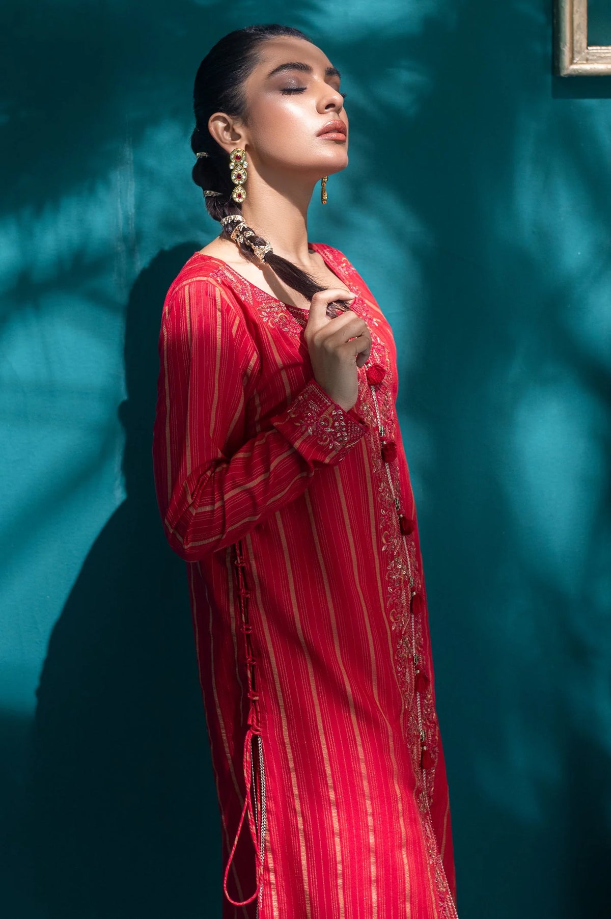 Side profile of ruby red embroidered jacquard kurti showcasing detailed gold threadwork, flowing sleeves, and traditional Pakistani craftsmanship