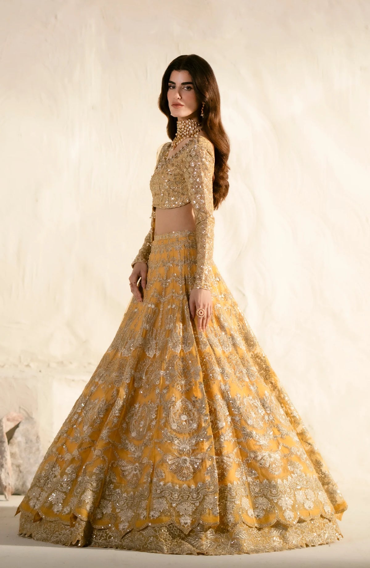 Side view of golden embroidered lehenga showcasing detailed craftsmanship and elegant silhouette with traditional Indian bridal wear styling.