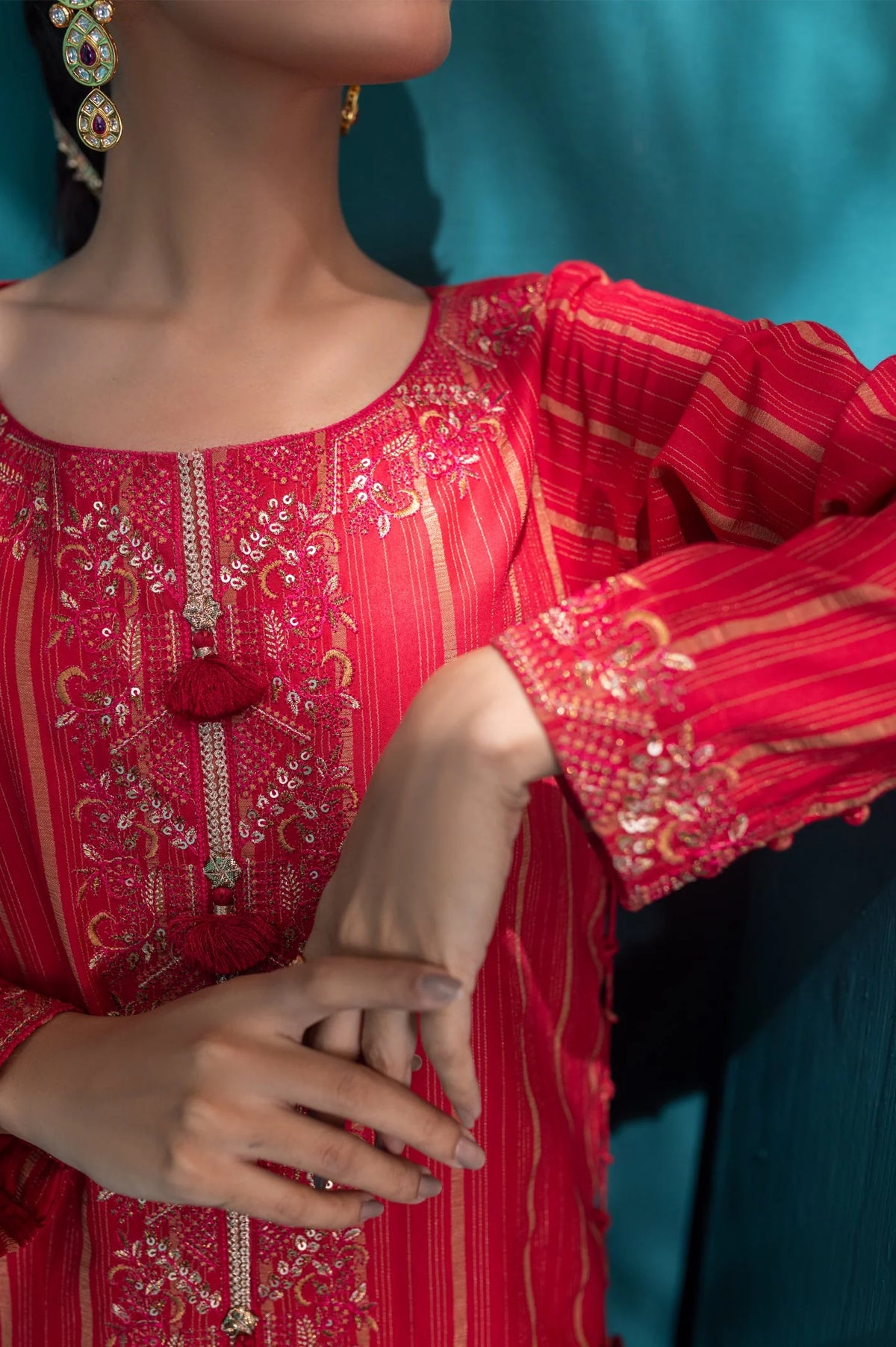 Close-up of ruby red embroidered jacquard kurti showcasing detailed gold threadwork, flowing sleeves, and traditional Pakistani craftsmanship