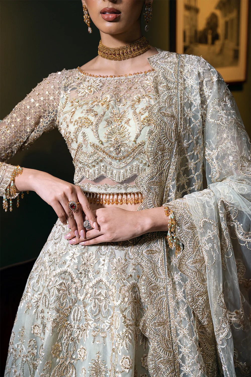 Detailed view of Pakistani bridal dress featuring intricate Chinese Silver embroidery on choli and dupatta, showcasing traditional craftsmanship with gold accents and beadwork on premium net fabric