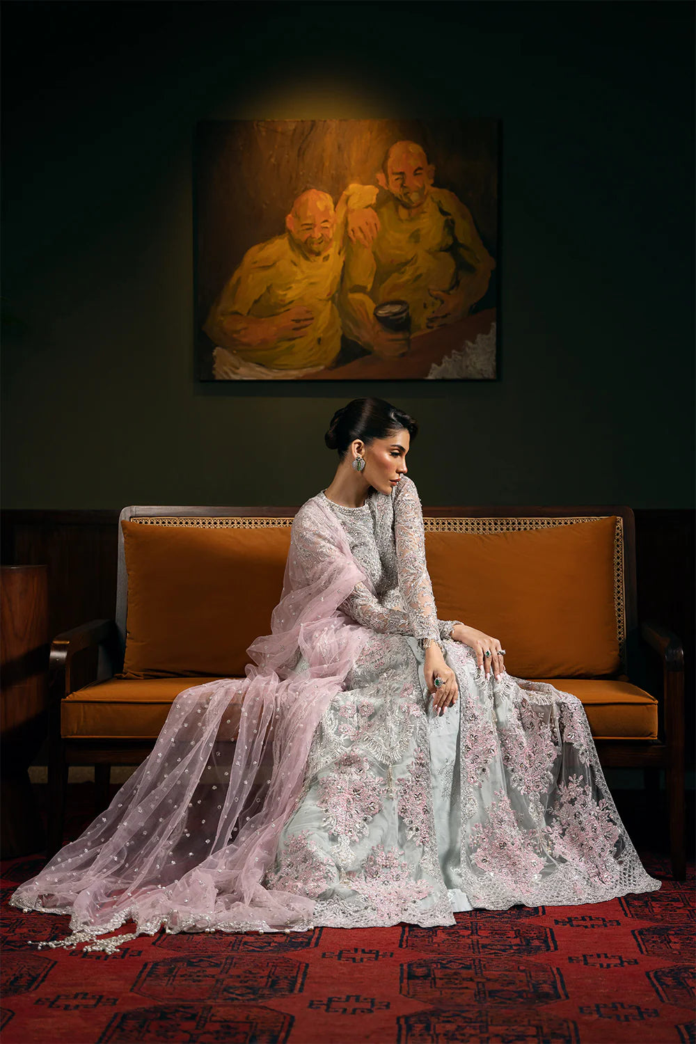 Complete Saira Rizwan bridal outfit seated view showing embroidered net and silk lehenga with flowing dupatta and traditional Pakistani bridal styling