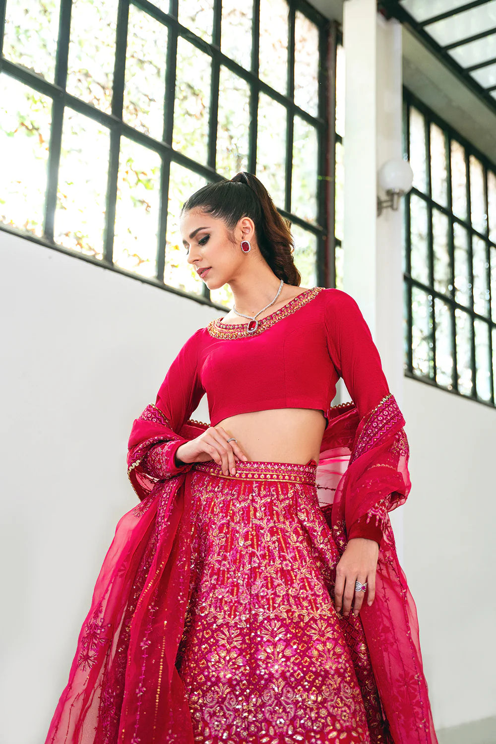 Saira Rizwan designer bridal outfit side pose - fuchsia pink choli lehenga with flowing organza dupatta - Pakistani bridal wear.