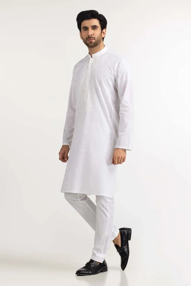 a man standing view of the white embroidered kurta for men by Gulahmed, showcasing its tailored fit and premium craftsmanship