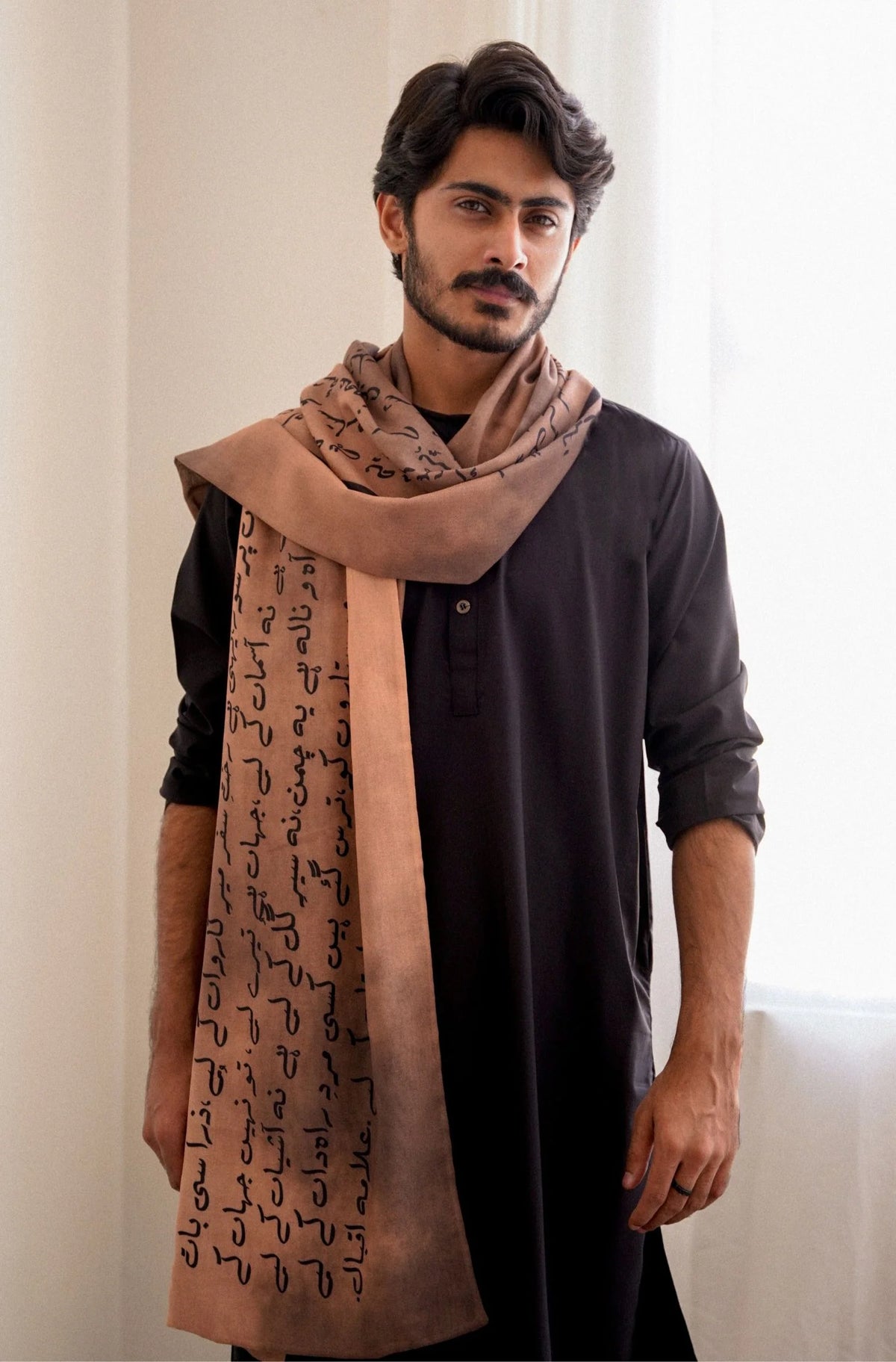 Male model wearing Manto Karvaan light brown stole with Arabic calligraphy - Pakistani men's fashion accessory
