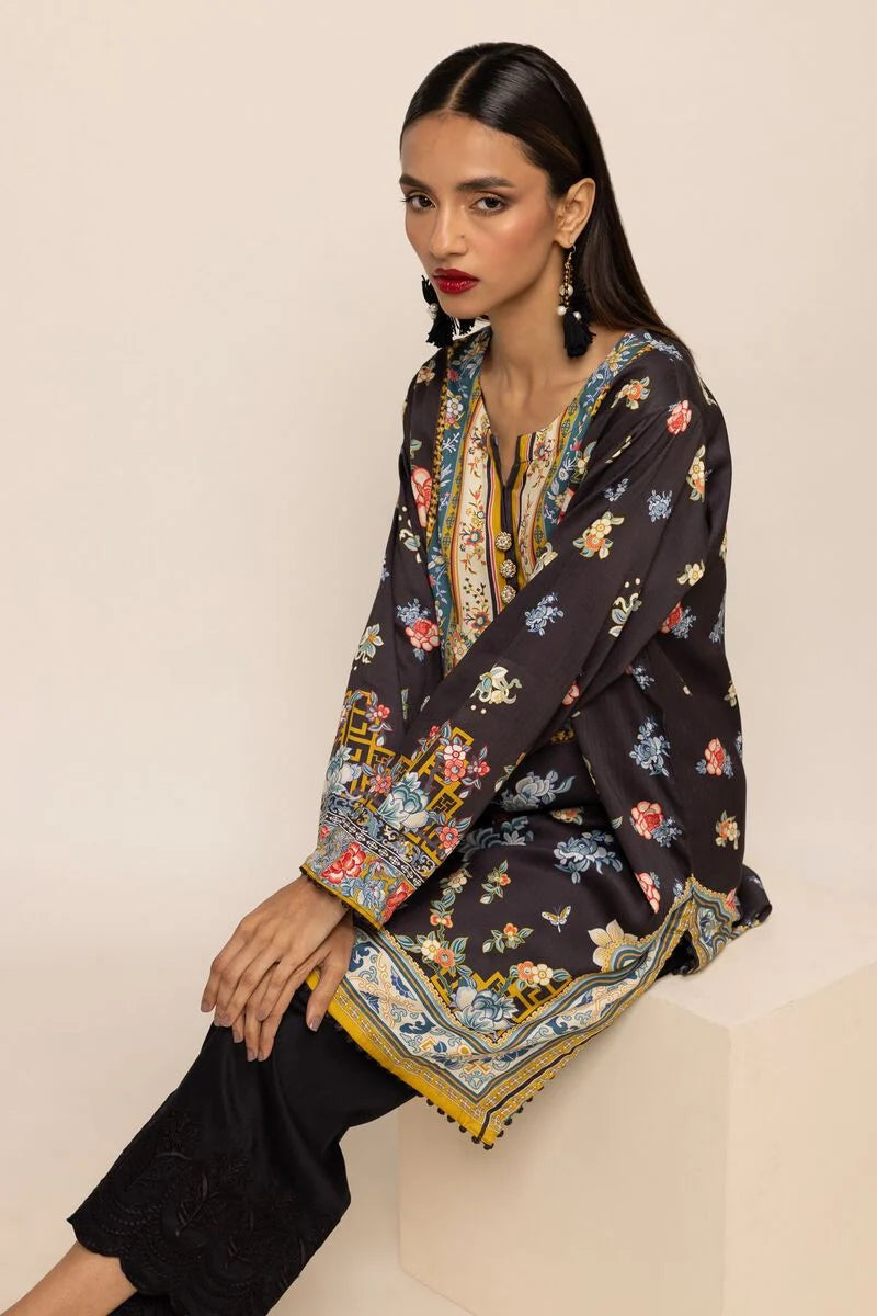 A woman wearing a medium-sized black full-sleeve viscose kurta from Khaadi – a perfect choice for traditional Pakistani clothes.