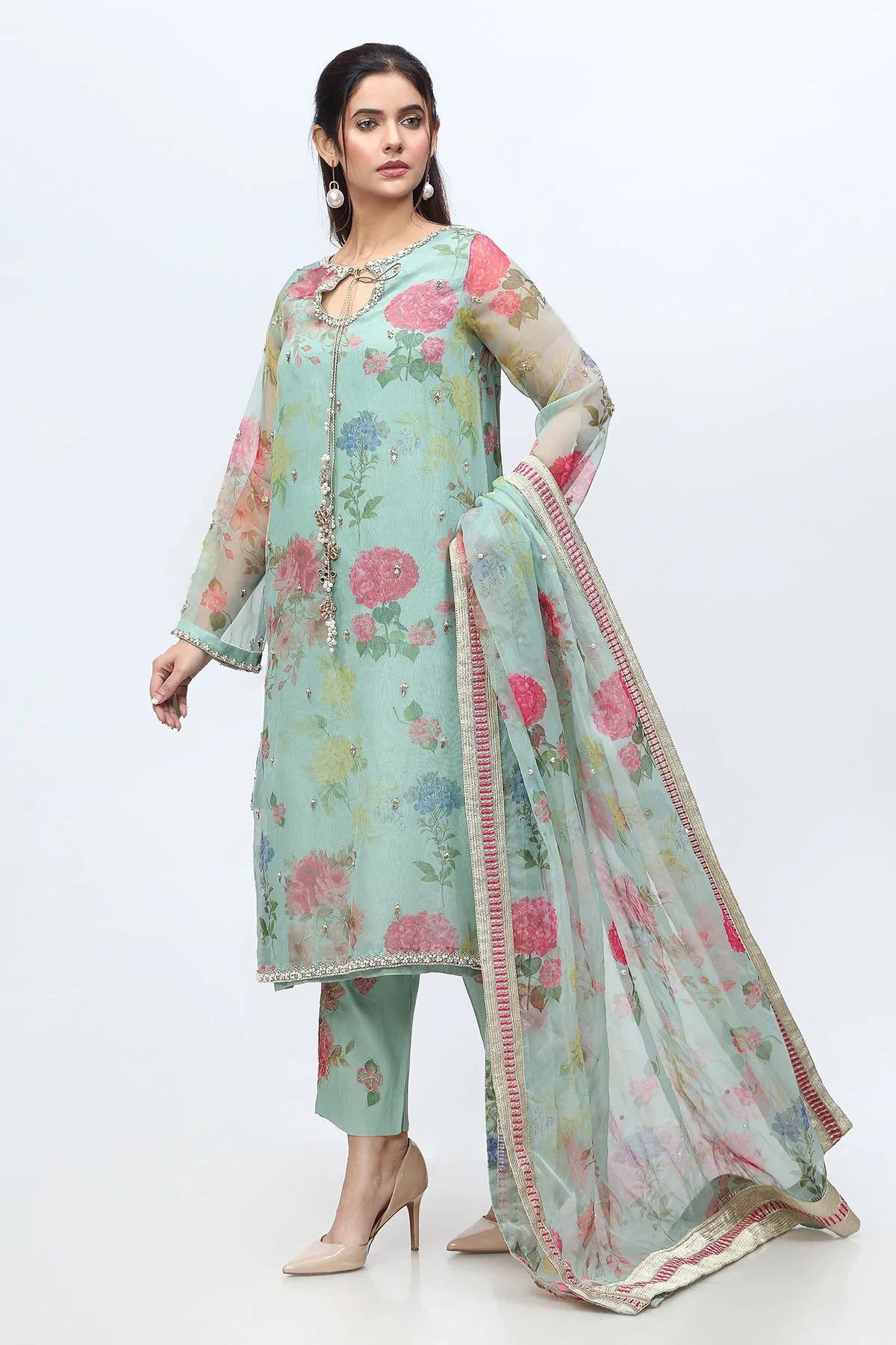  Left profile of the light green Charizma suit, showcasing its fine raw silk trouser and detailed organza dupatta.