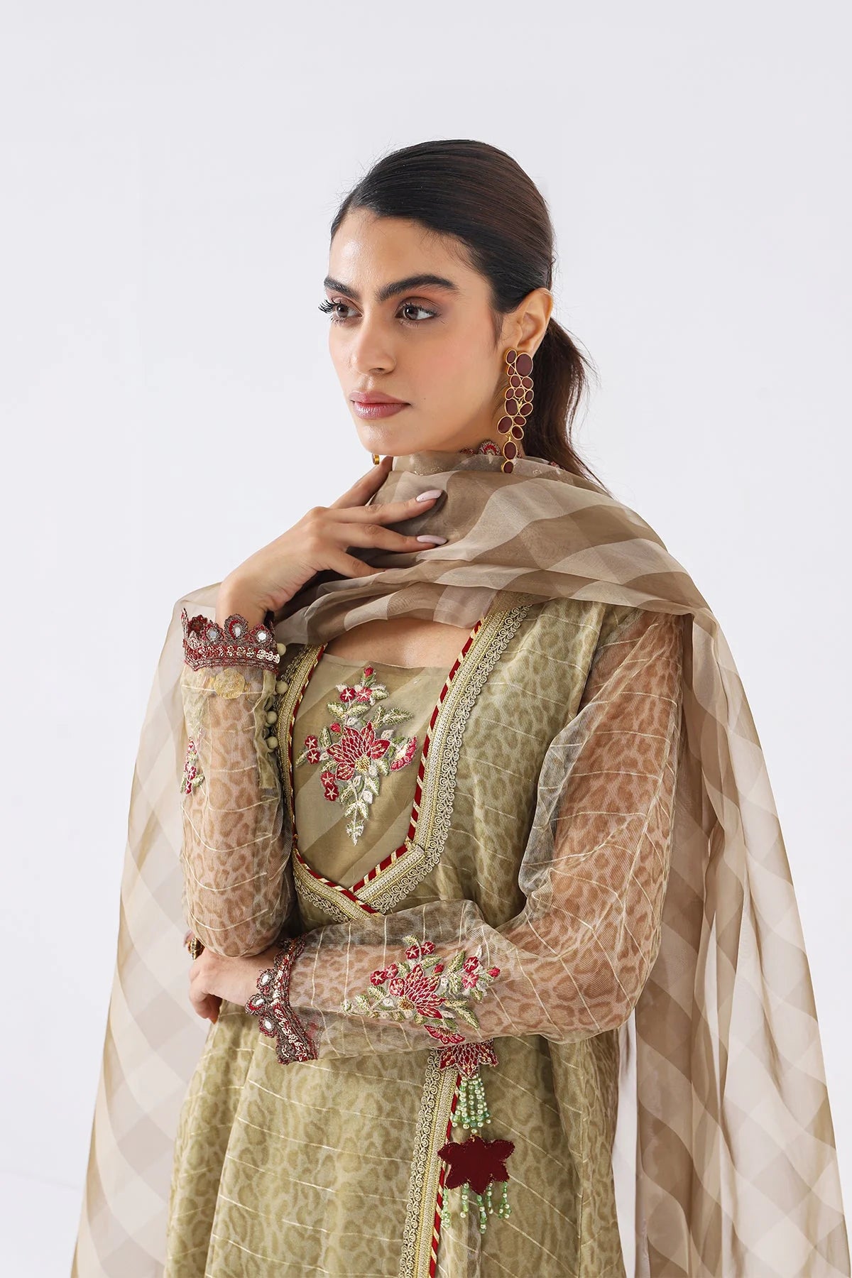A woman wearing a medium-size sea green Charizma 3-PC embroidered suit – a stunning choice for Pakistani suits online in Canada.