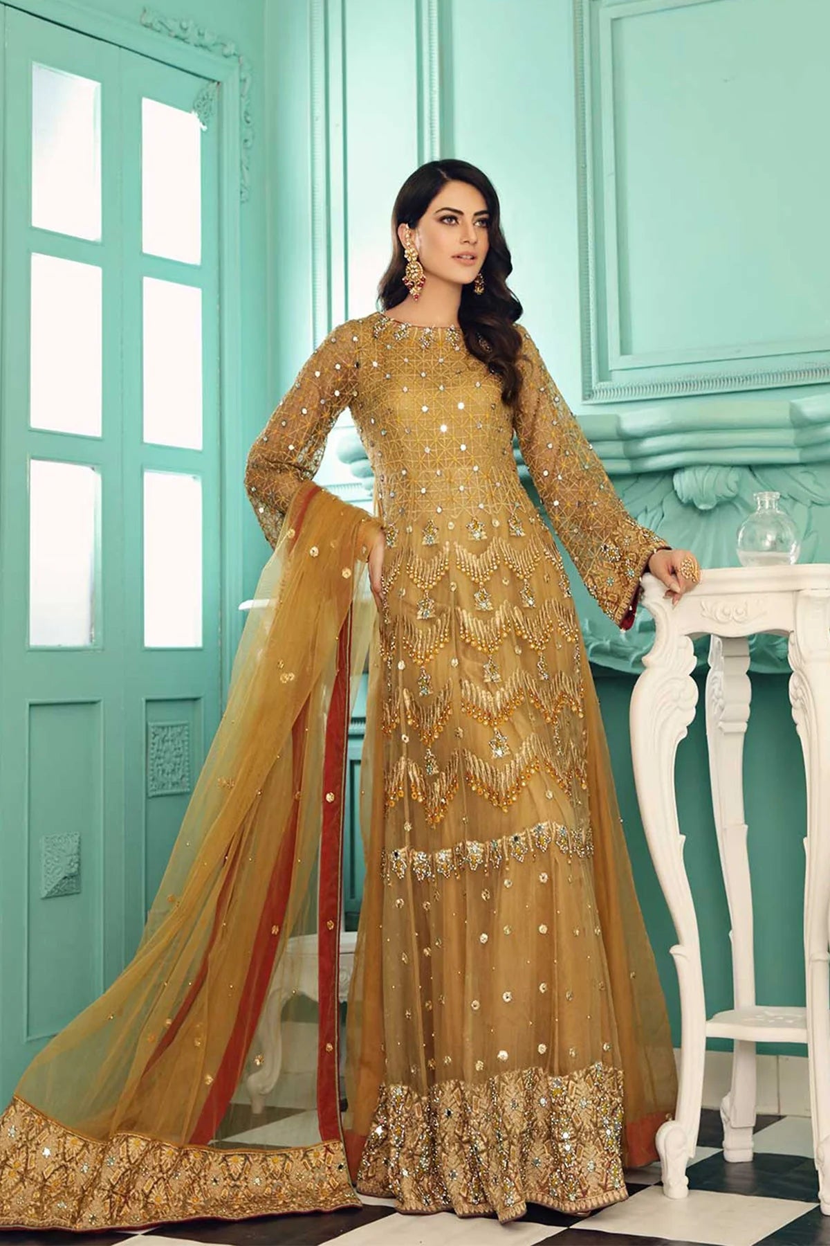 A woman wearing a medium-size Charizma golden embroidered 3PC suit – a stunning option for Pakistani suits online in Canada.