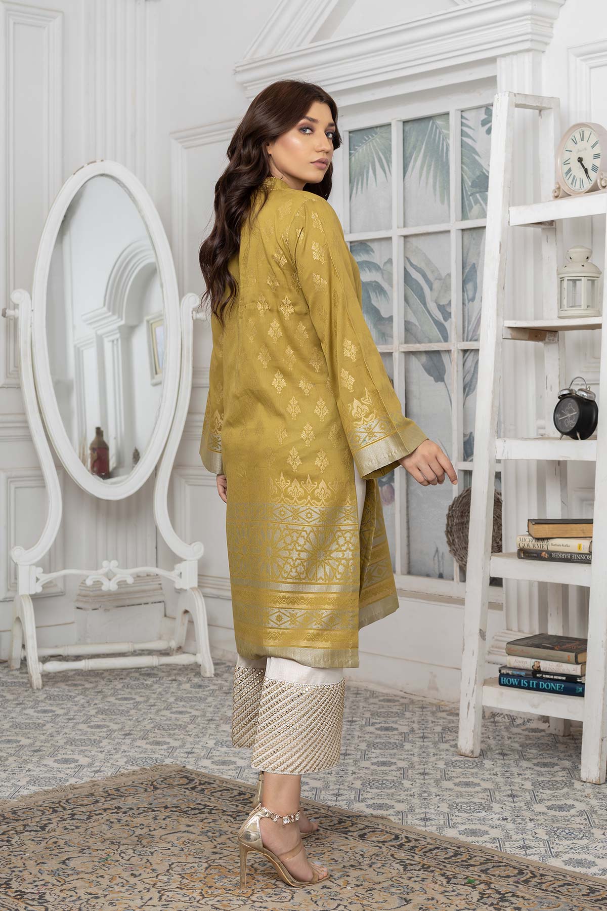 lady showing back view of Charisma’s olive green jacquard lawn shirt with back lace details – a perfect addition to your Pakistani wardrobe in Canada.