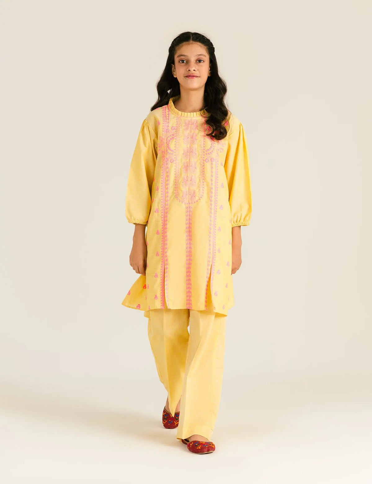 A 9-10-year-old girl wearing a neon yellow embroidered cotton suit by Beechtree – a vibrant pick for Pakistani suits online in Canada.