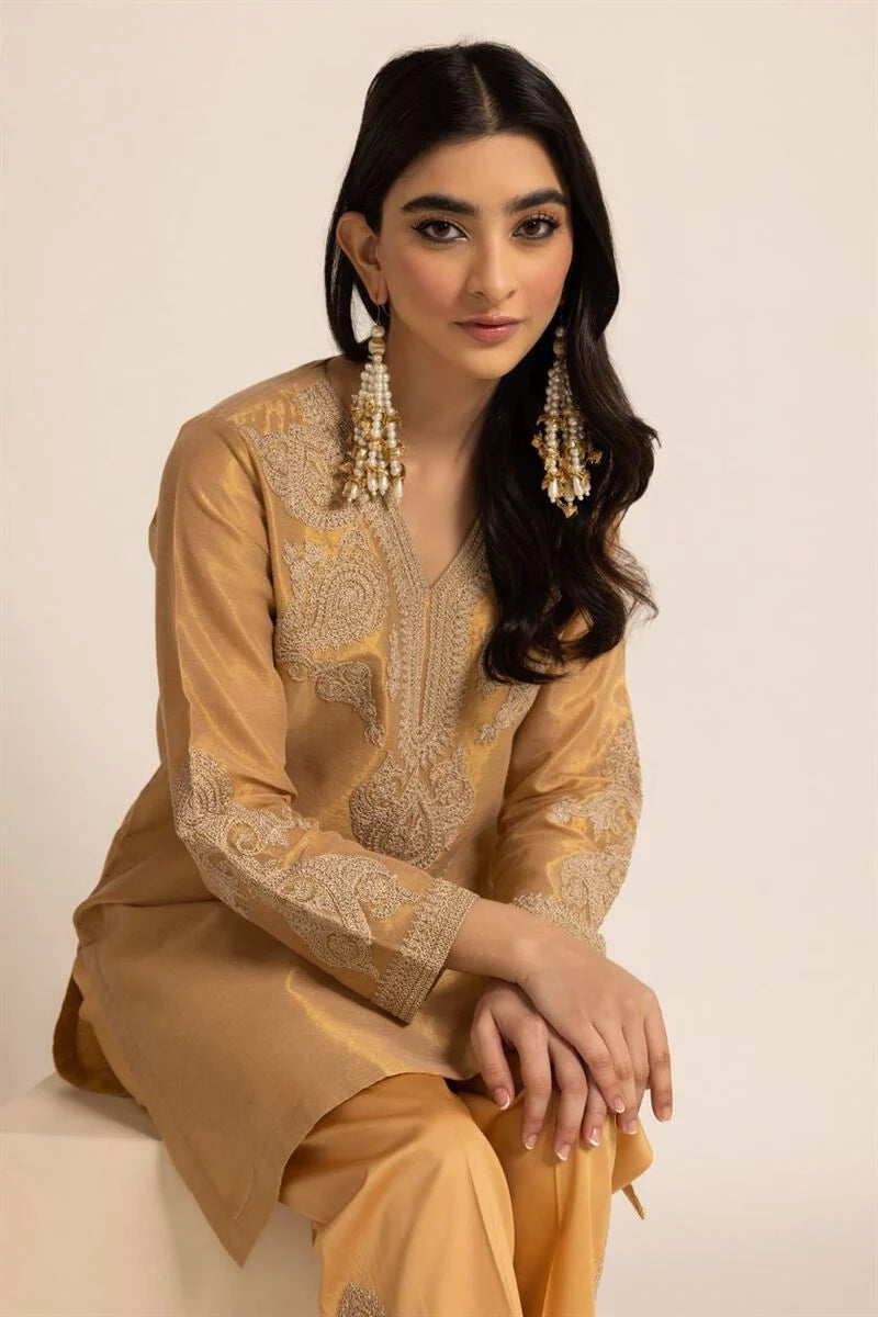  A woman wearing a medium-size Khaadi embroidered kurta, showcasing intricate threadwork on a premium cotton base.