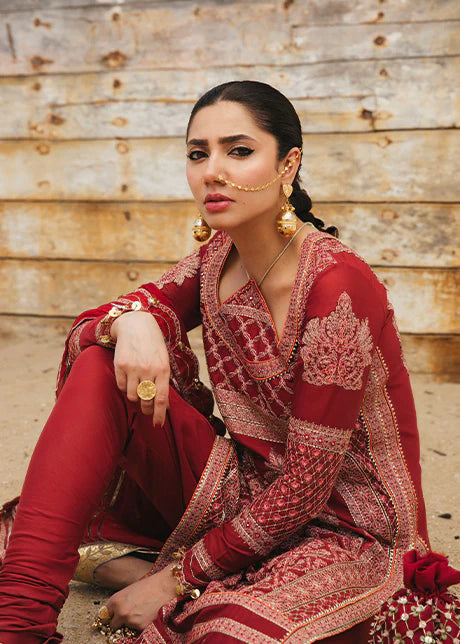 Casual pose showcasing Hussain Rehar maroon embroidered Pakistani suit with gold detailing