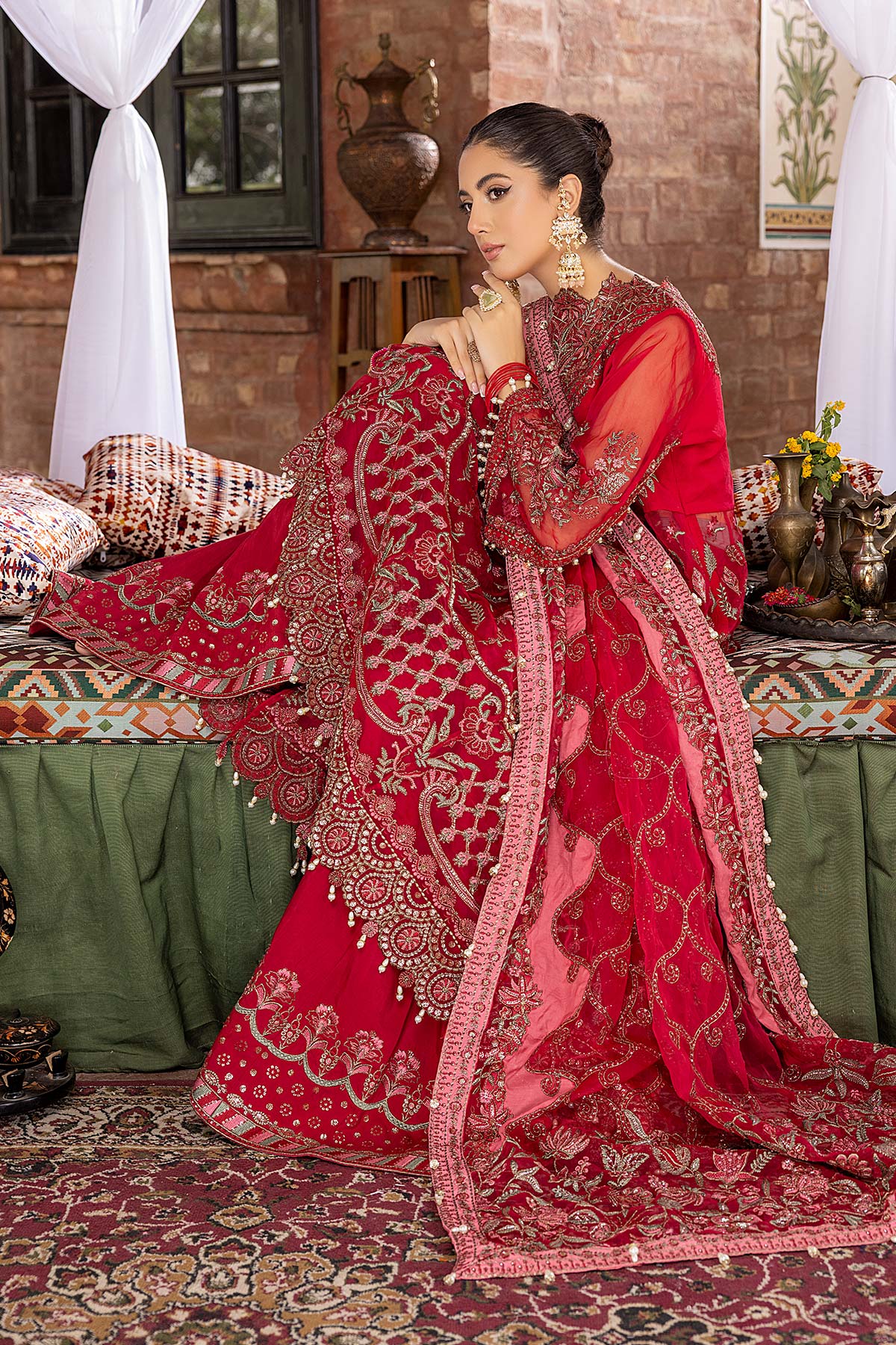 A graceful lady wearing red organza maxi by Charizma, showcasing exquisite embroidery and luxurious fabric, perfect for weddings.