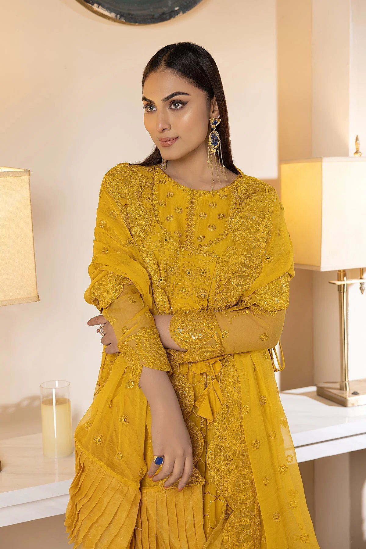 Detailed embroidery on the yellow raw silk sharara, showcasing elegant Pakistani fashion.