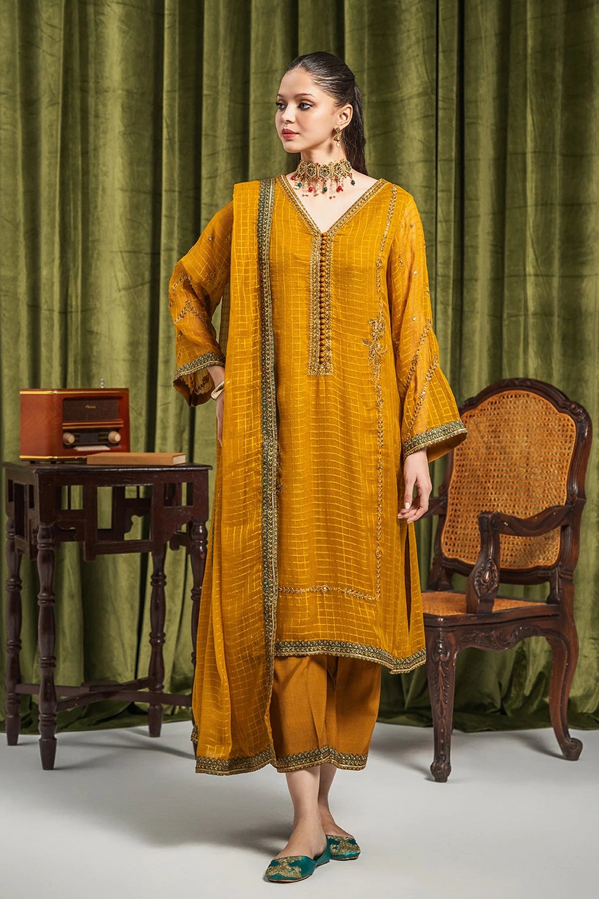 A woman wearing a medium-size yellow mustard embroidered chiffon suit from Charizma – a top choice for Pakistani suits online in Canada.