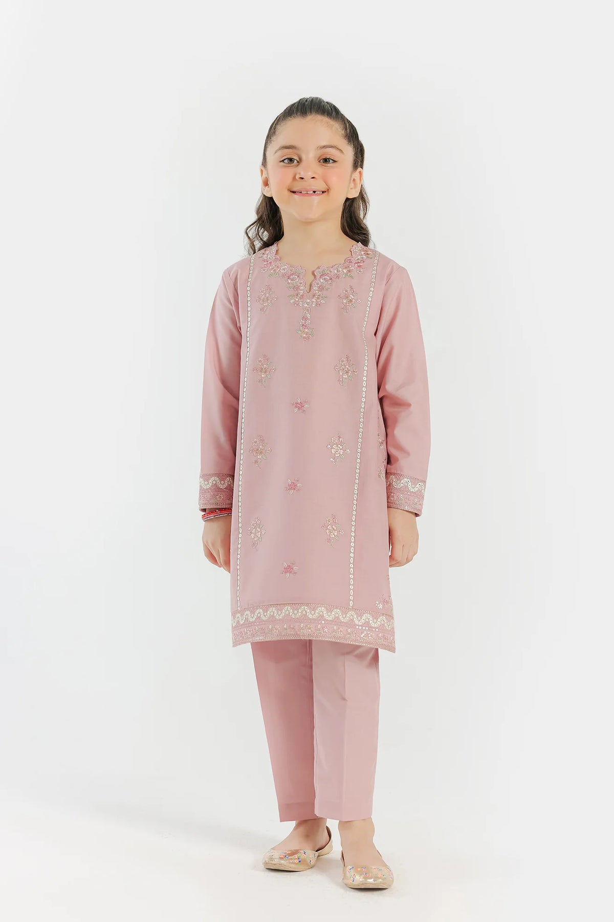 A 5-6 years old girl wearing an elegant pale coral embroidered lawn suit by Ethnic – a refined choice for Pakistani suits online in Canada.