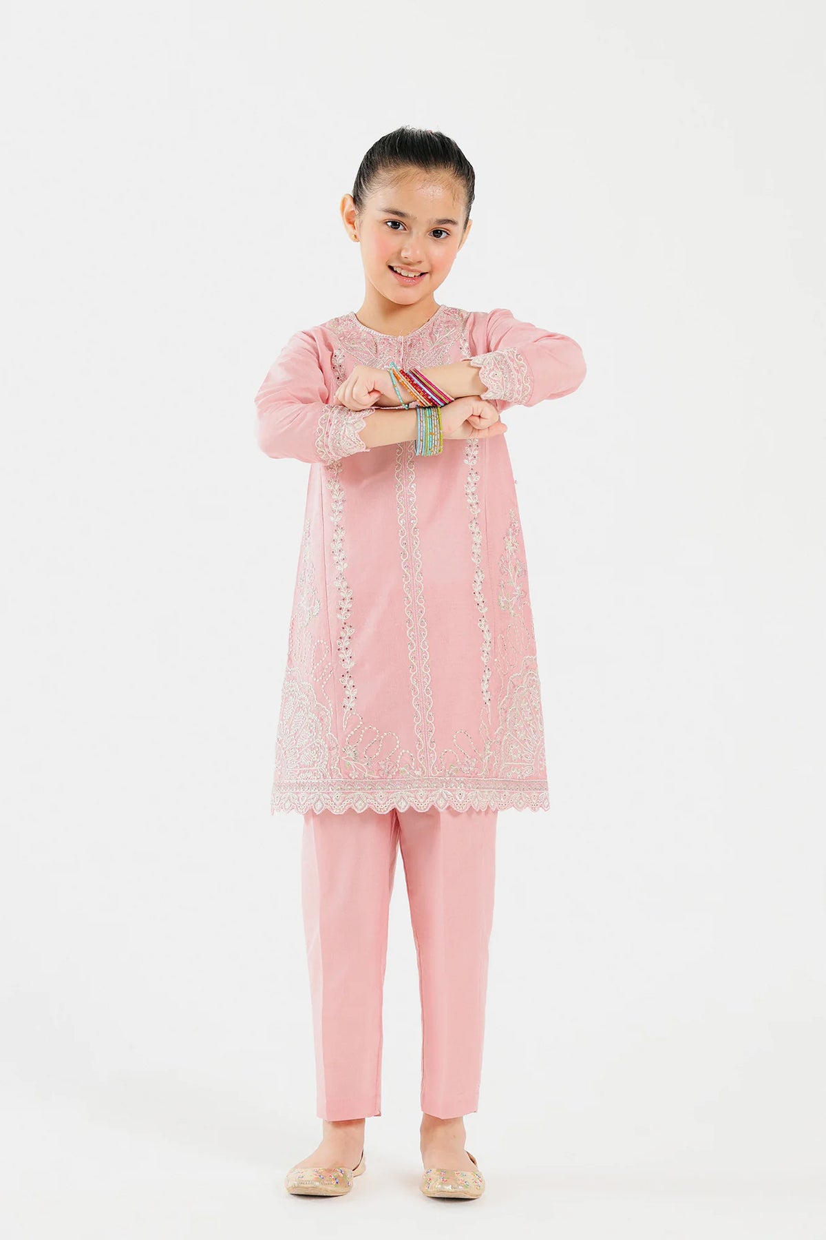  An 8-9-year-old girl wearing an elegant powder coral embroidered suit by Ethnic – a premium choice for Pakistani suits online in Canada.