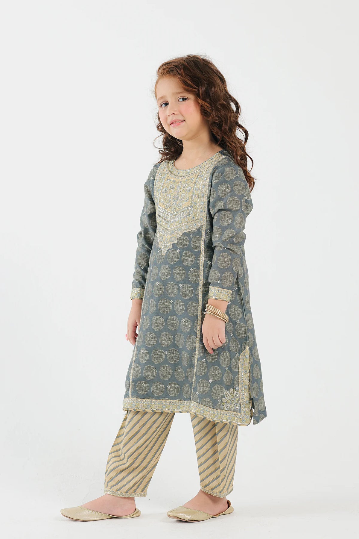8-9 years of kid with Side profile of Ethnic’s light grey embroidered suit, showcasing intricate floral embroidery – a top pick for Pakistani suits for kids.