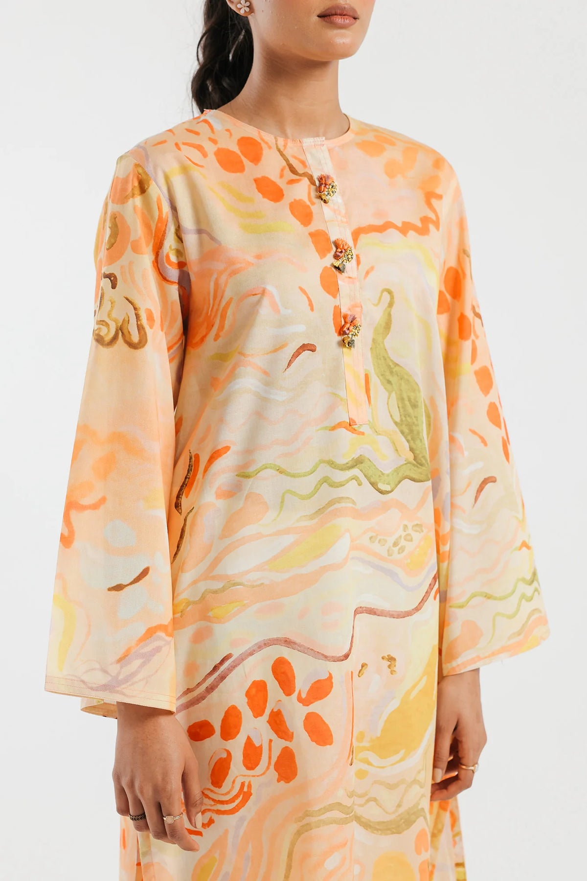 women showing close-up of fabric close-up of Ethnic’s printed shirt, offering comfort and style in traditional Pakistani fashion.