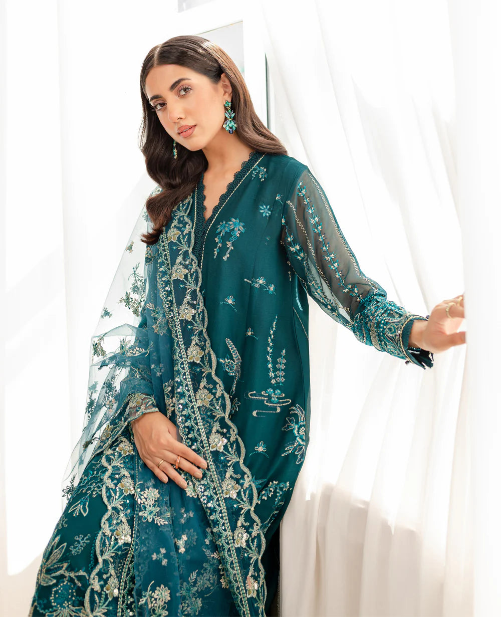 a lady standing with a embroidered chiffon fabric on Xenia’s eagle green suit – a must-have for Punjabi suits lovers in Canada.
