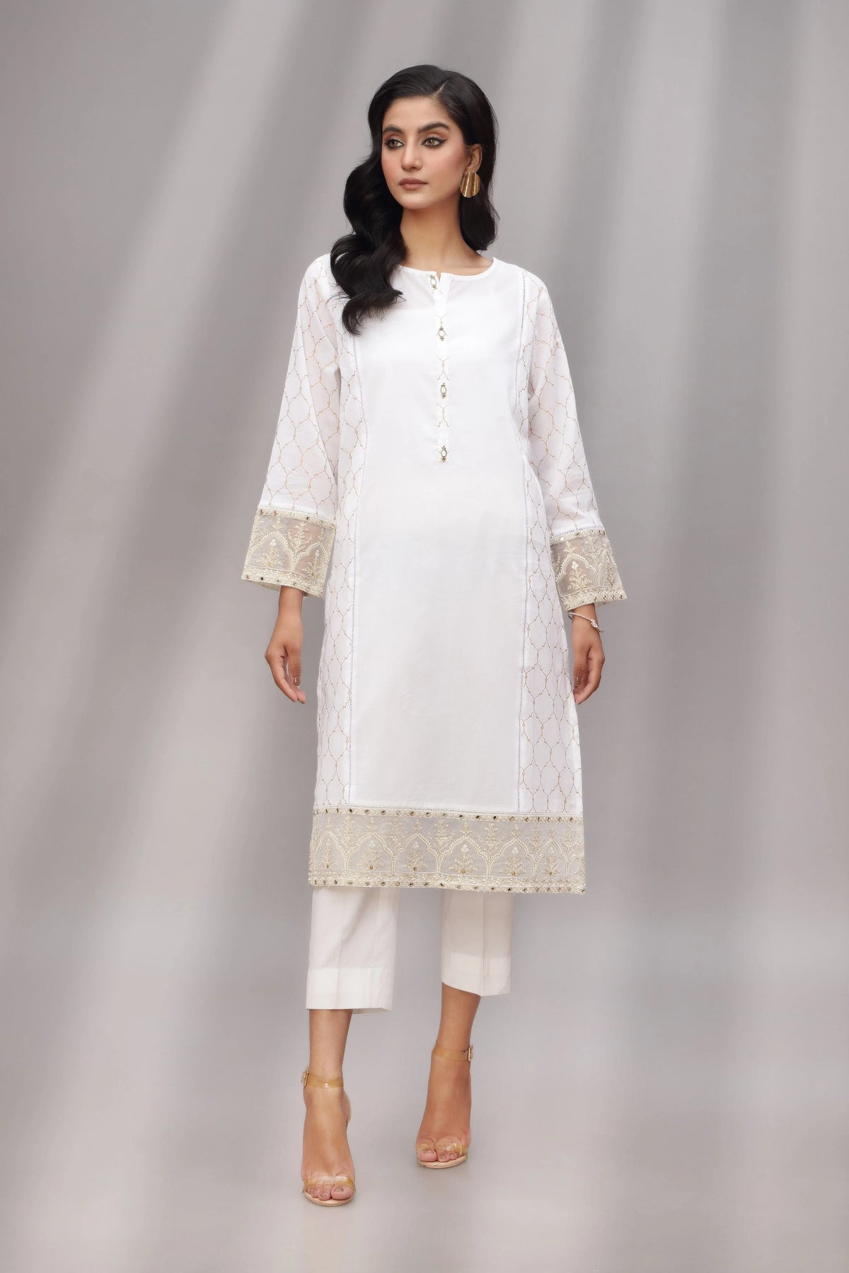 A woman wearing a medium-size Chinyere white printed lawn shirt, a top choice for Pakistani suits online in Canada.