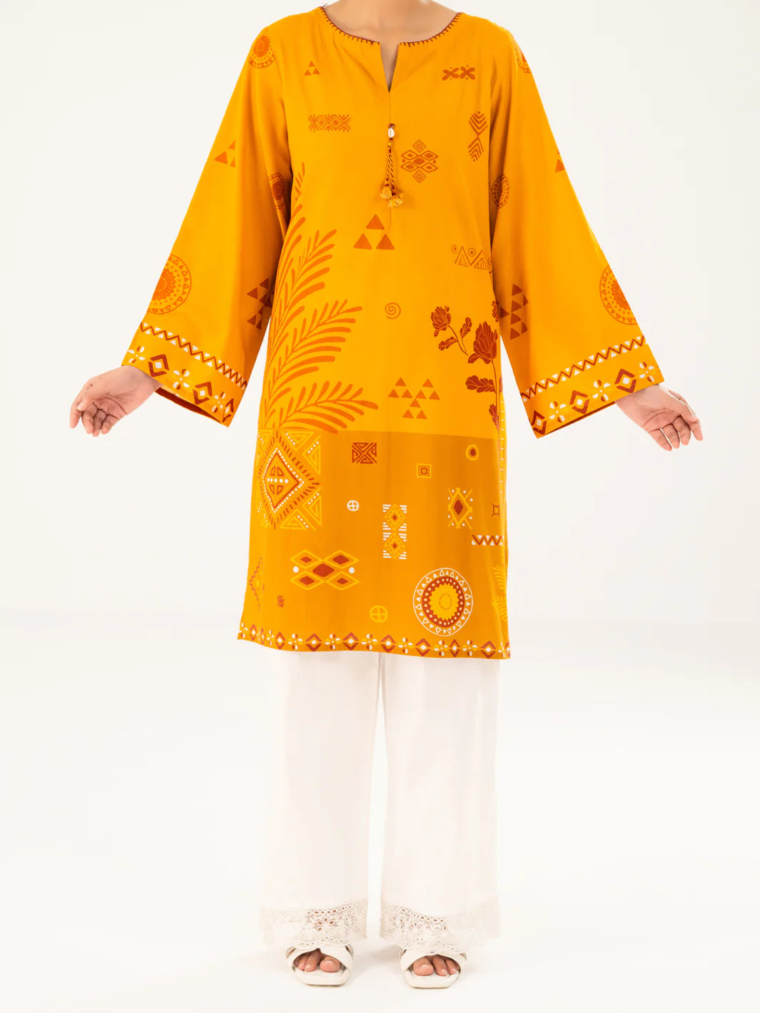 Woman standing 3-quarter view hand on hip mustard geometric cambric kurti tassel neckline mirror cuffs Almirah Eid Pakistani suits Canada