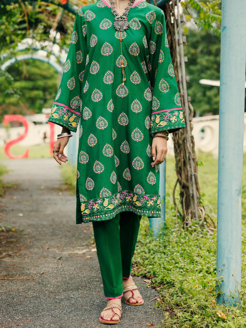 Woman walking front view full length emerald green paisley lawn kurti tassel neckline embroidered cuff hem Almirah Eid Pakistani suits Canada