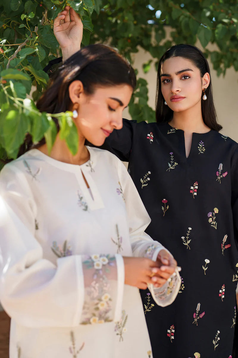 Side-by-side comparison of off white and black embroidered lawn suits by Baroque, featuring intricate floral motifs and traditional Pakistani craftsmanship