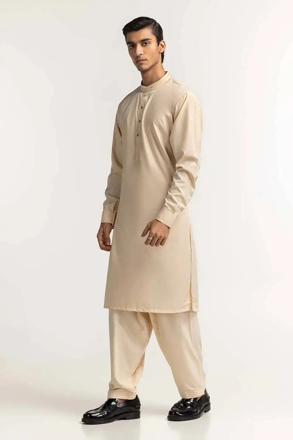 Side profile of GulAhmed’s cream suit, showcasing its elegant fit – a top pick for Pakistani suits for men in Canada.