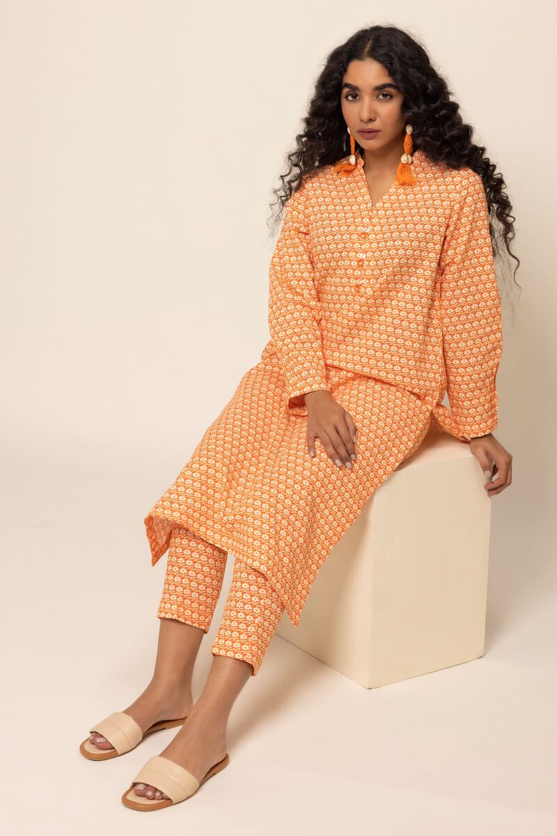 A woman wearing a stylish smart-fit orange cotton kurta by Khaadi, a premium option for Pakistani suits online in Canada.