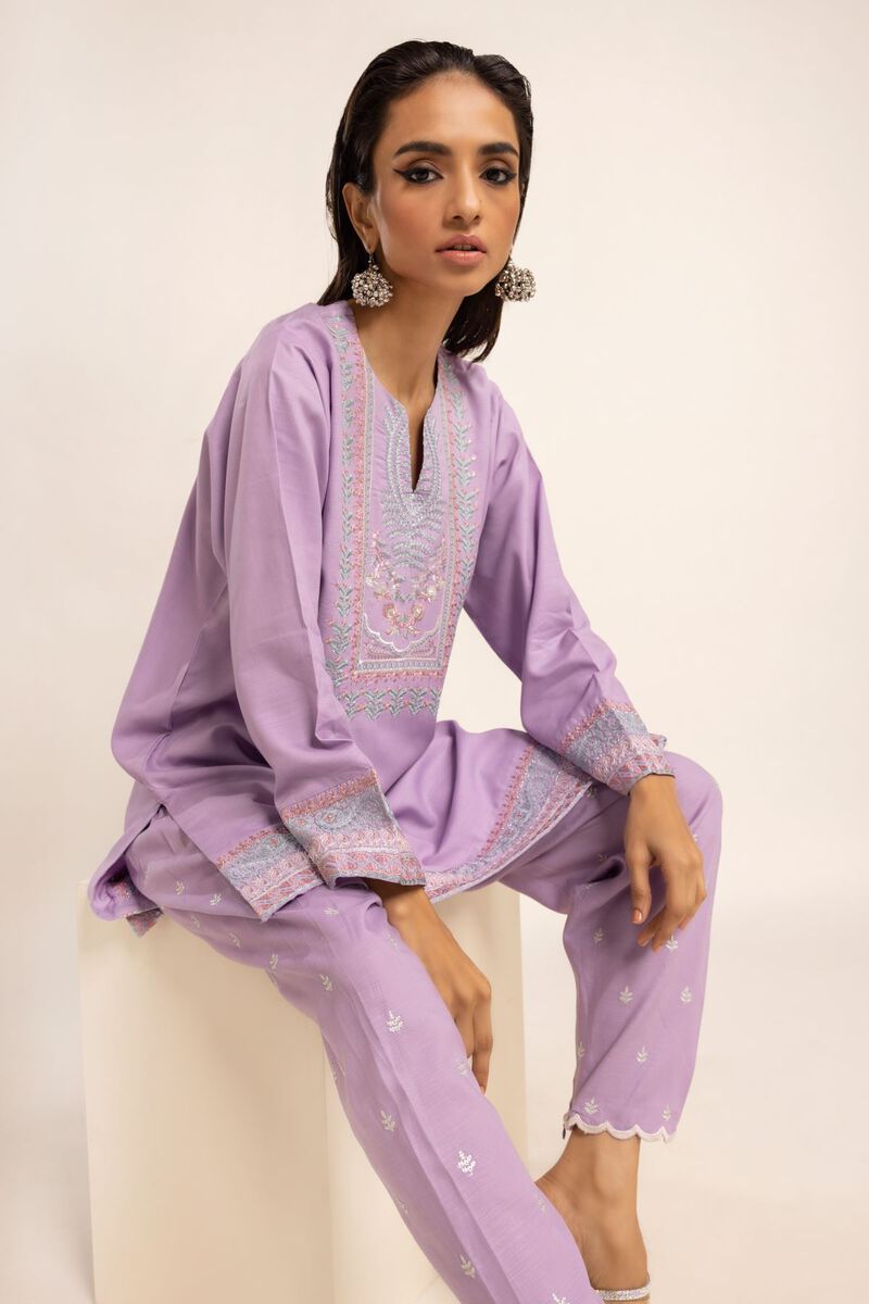 women sitting for a Close-up of the Khaadi embroidered kurta, highlighting intricate embroidery and a soft viscose cotton blend—perfect for Punjabi suits.