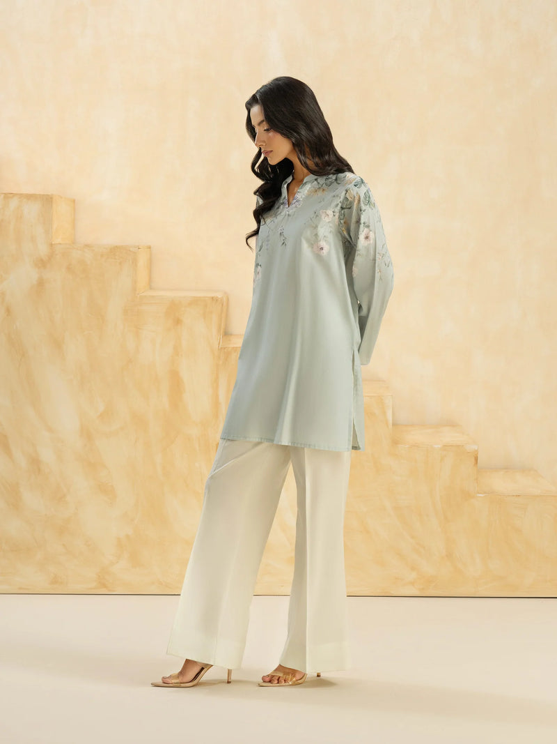 Woman standing side angles view full length sky blue printed slub cambric casual top lace cuff Limelight Eid Pakistani suits Canada