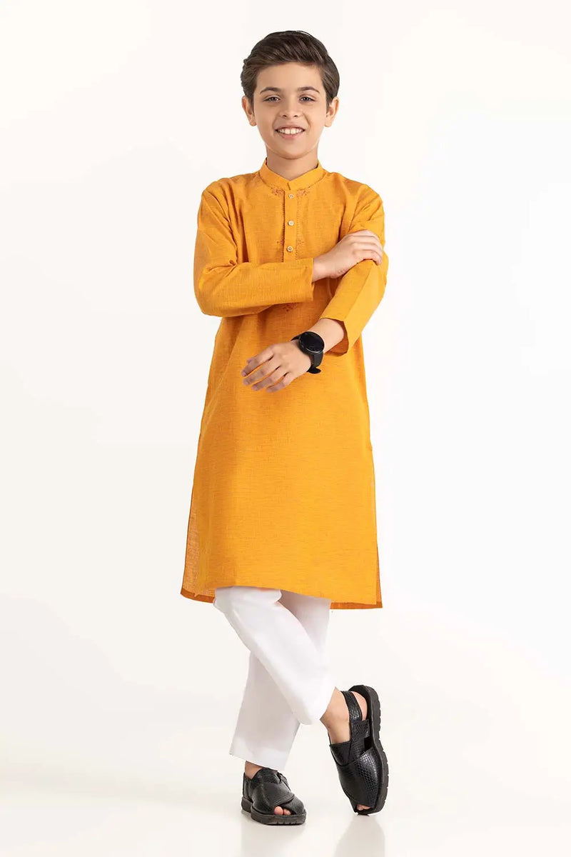 A young boy wearing a marigold embroidered cotton kurta from Gulahmed – a Pakistani outfit for kids.