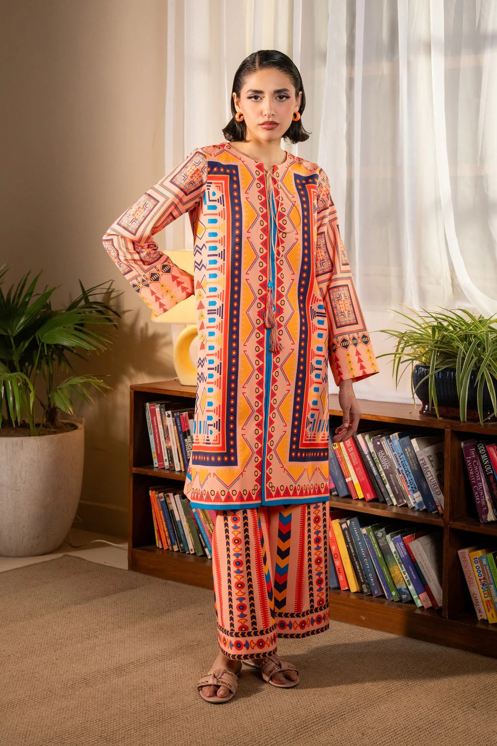 Woman standing front view full length hand on hip peach printed crepe 2-piece suit Maryum N Maria Eid Pakistani suits Canada