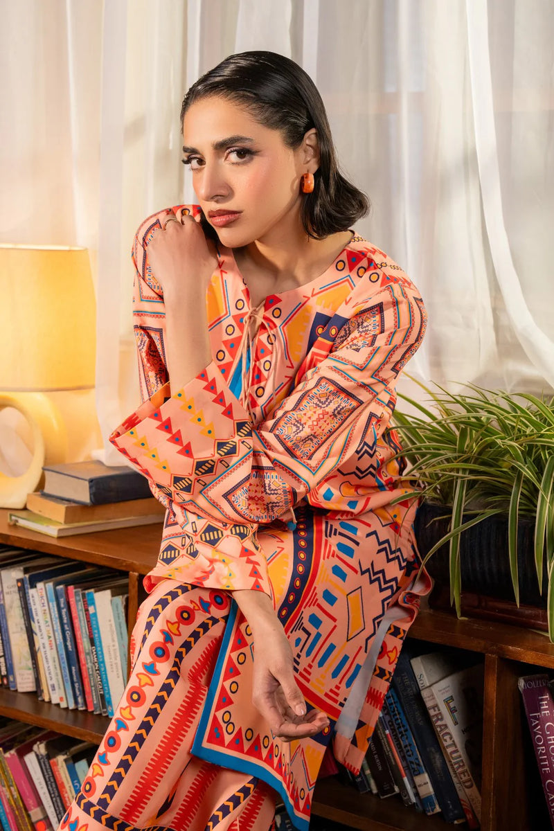 Woman sitting leaning portrait close-up peach tribal print crepe suit Maryum N Maria Eid Diwali Pakistani suits Canada women