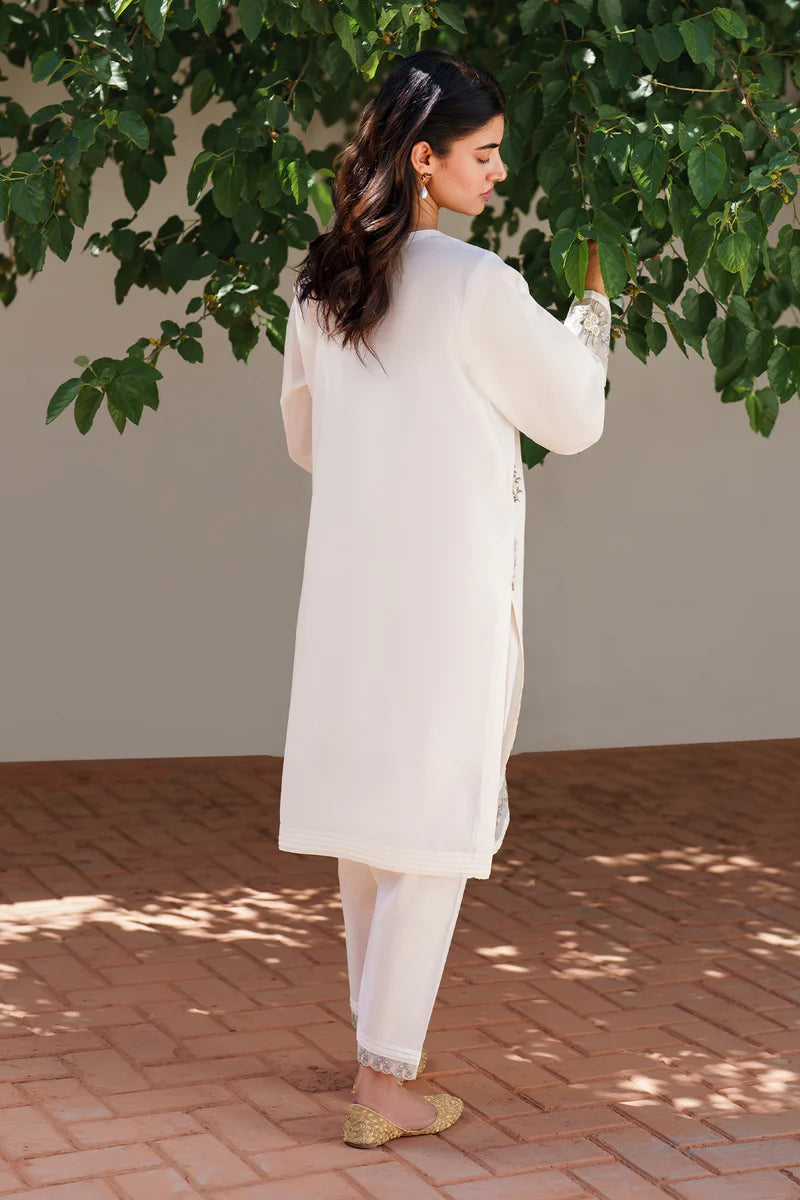 Back view of off white embroidered lawn suit displaying elegant drape, detailed embroidery work, and traditional Pakistani formal wear styling