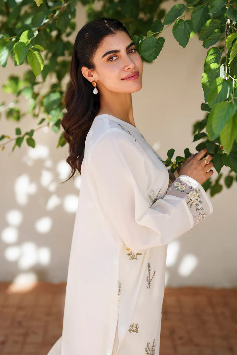 Side profile of off white embroidered lawn outfit displaying elegant silhouette, detailed embroidery work, and flowing sleeves for casual sophistication