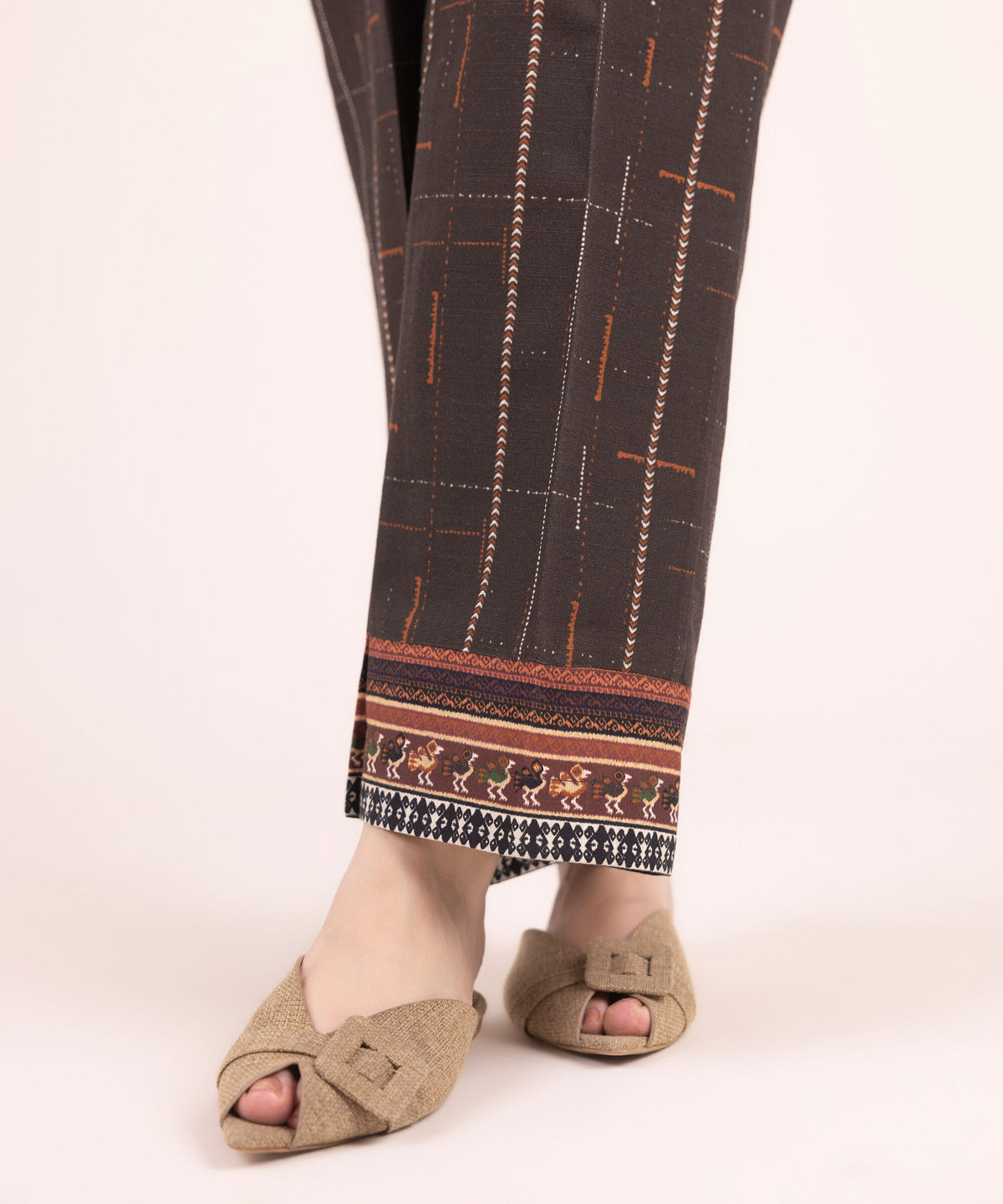 Woman walking side angle Sapphire brown printed Pakistani suits Canada straight pants tribal figurine hem dewali