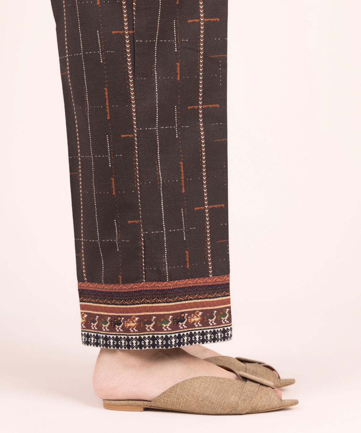 Woman side close-up Sapphire brown printed Punjabi suits straight pants tribal figurine diamond hem festive