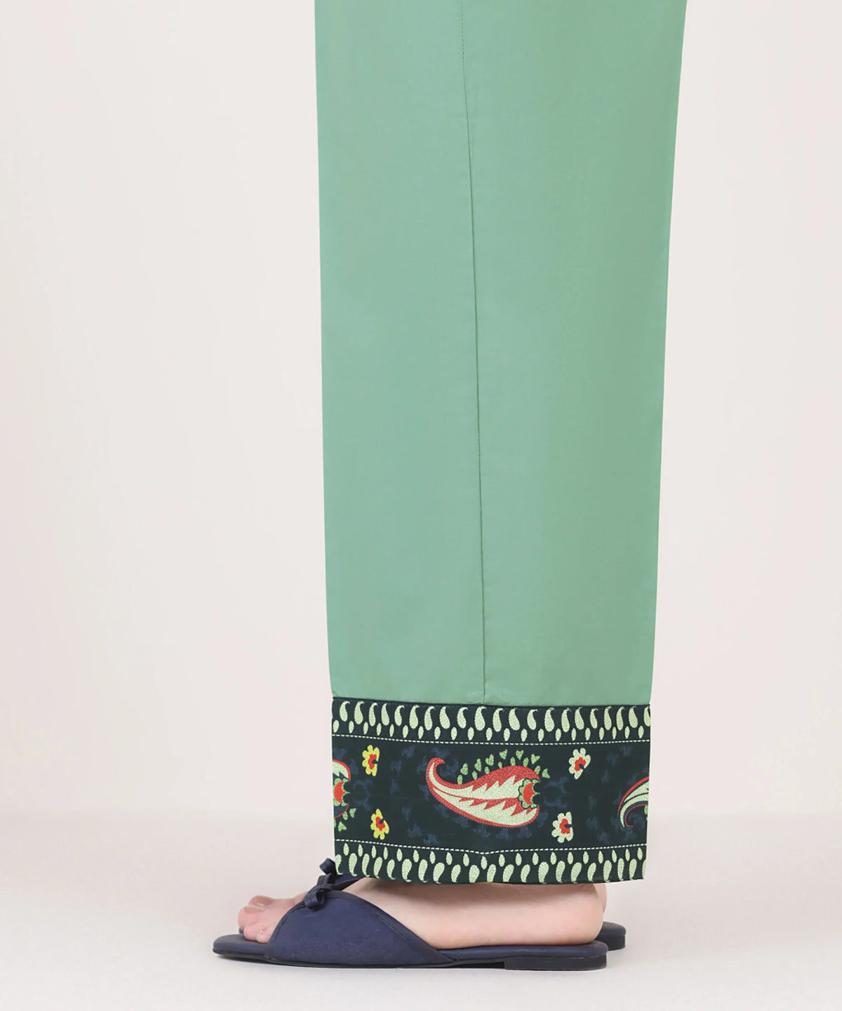 Woman angled side view Sapphire green cambric pants printed paisley border side slit open – Pakistani suits online Canada