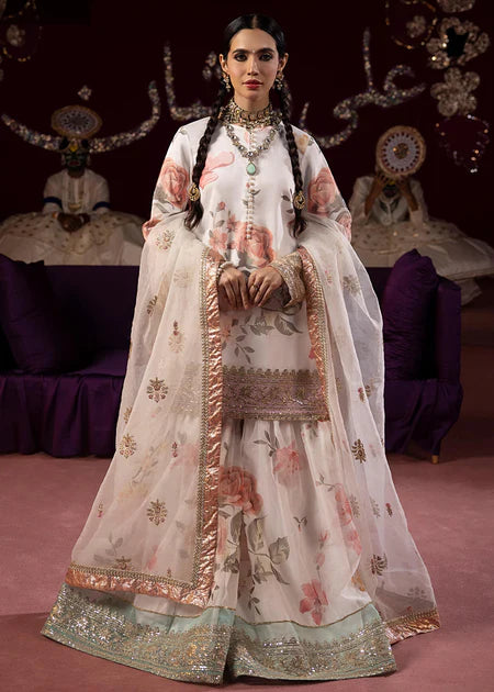 Front view of white floral sharara suit featuring delicate rose prints, gold embellished borders, and flowing palazzo pants with dupatta.