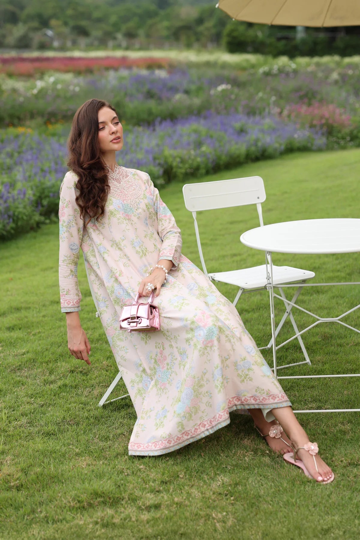 Woman seated leaning full length front view Xenia cream floral embroidered lawn gown Diwali Eid festive Pakistani suits Canada