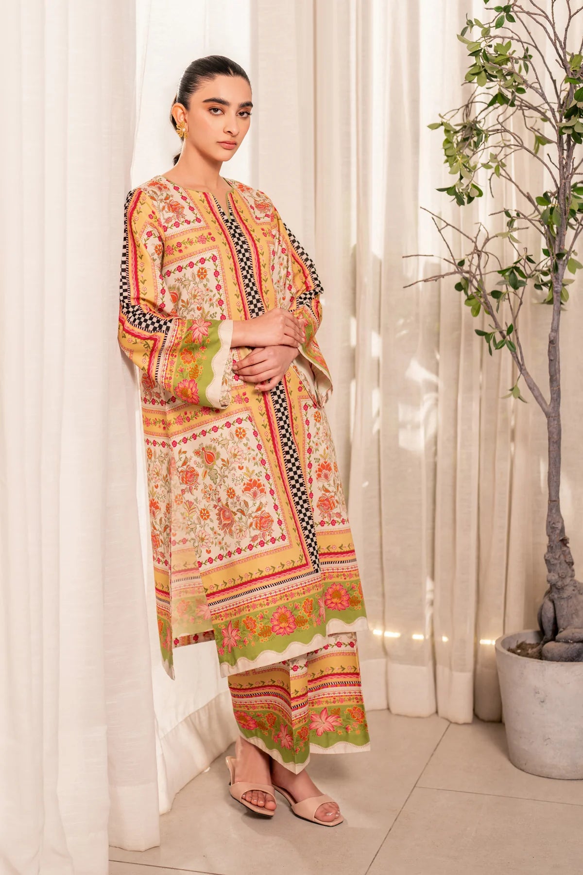 Woman standing leaning with curtain showing full length front view Xenia Elia floral printed lawn suit festive wedding Punjabi suits Canada